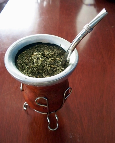 Top view of mate gourd full of green mate with bombilla.